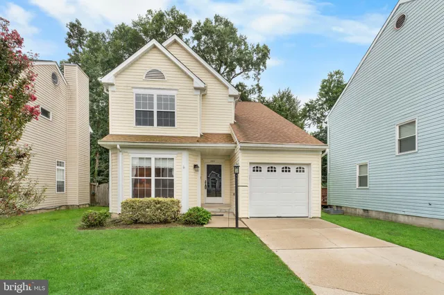 a view of a yard in front of a house with a large tree