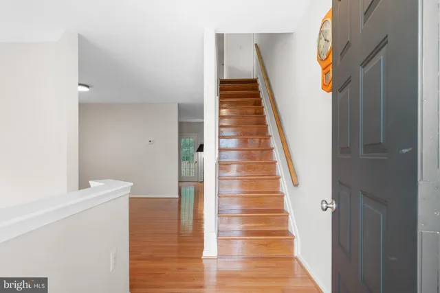 a view of a hallway with wooden floor and staircase