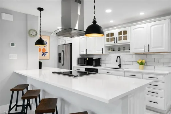 a kitchen with stainless steel appliances a sink a stove a refrigerator and cabinets
