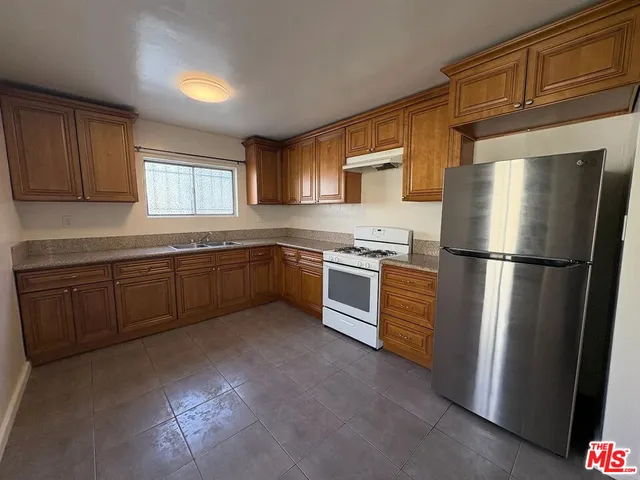 a kitchen with stainless steel appliances granite countertop a refrigerator sink and cabinets