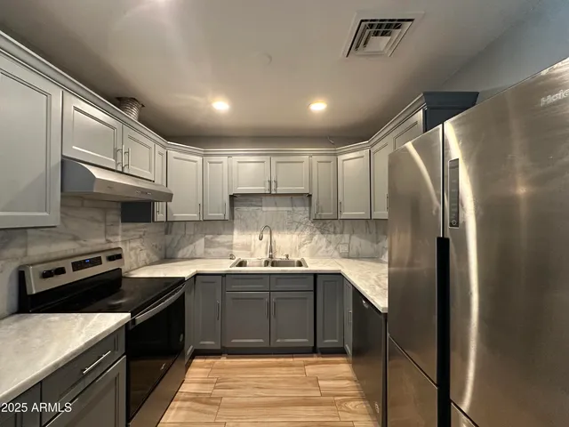 a kitchen with stainless steel appliances granite countertop a sink stove and refrigerator