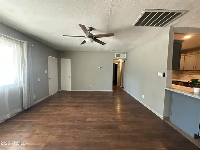 a view of a livingroom with a ceiling fan and wooden floor