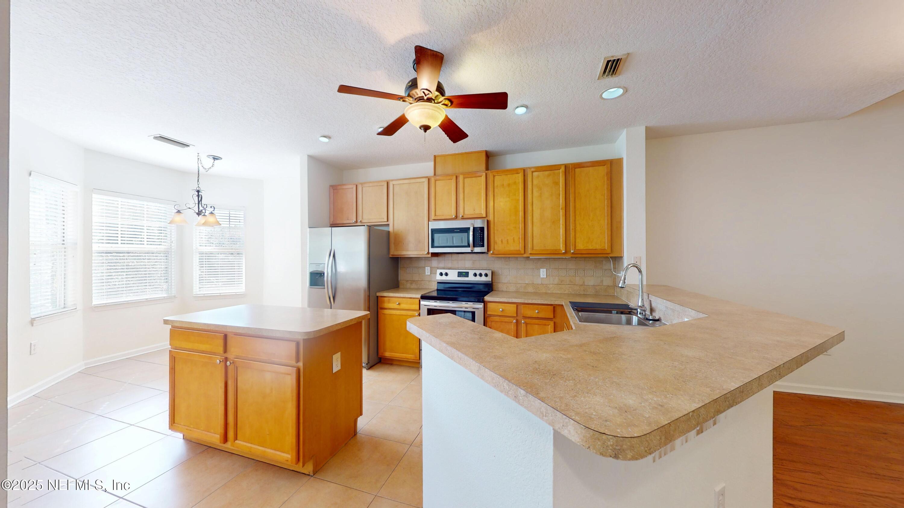 5663 Greenland Road, Unit 1004 Jacksonville, FL 32258 - Photo 5 of 35 a kitchen with stainless steel appliances granite countertop a sink a stove and a refrigerator