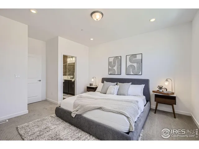 a bedroom with a bed and a painting on the wall