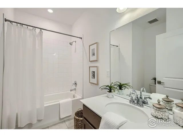 a bathroom with a bathtub sink vanity and shower