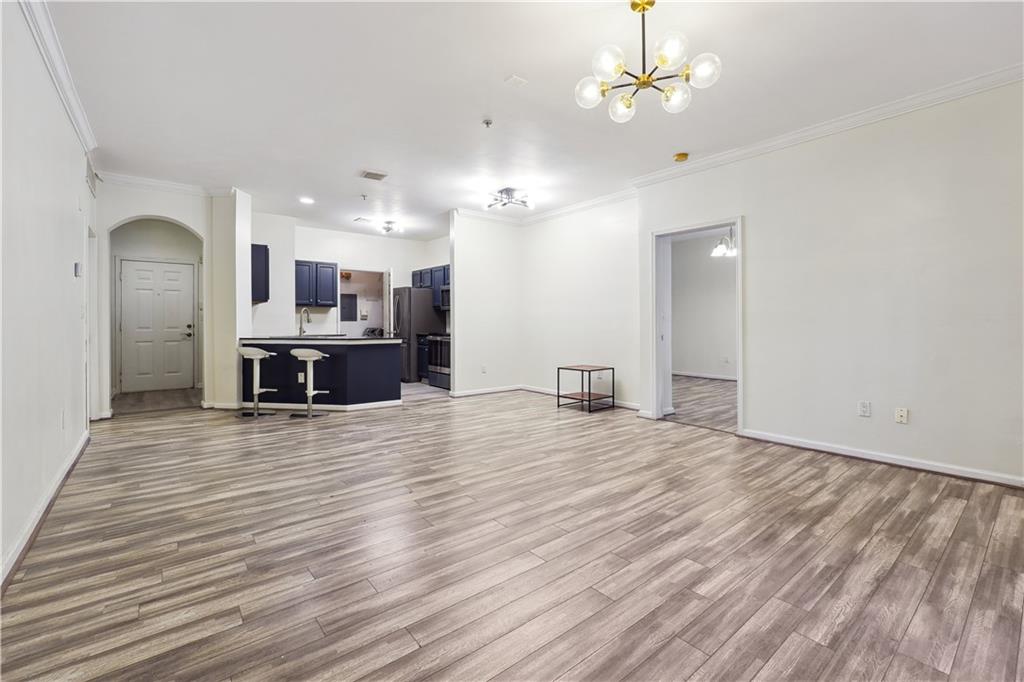 5641 Roswell Road, Unit 103 Atlanta, GA 30342 - Photo 7 of 27 an empty room with kitchen appliances and a chandelier fan
