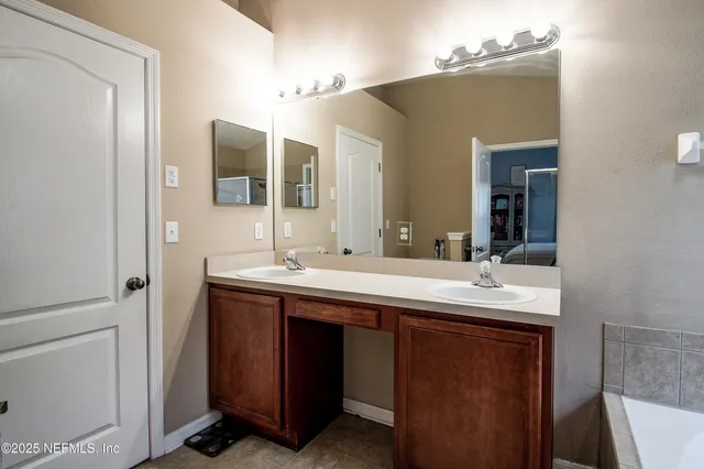 a bathroom with a double vanity sink and mirror