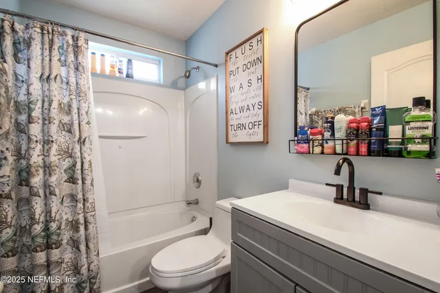 a bathroom with a sink a toilet and shower curtain
