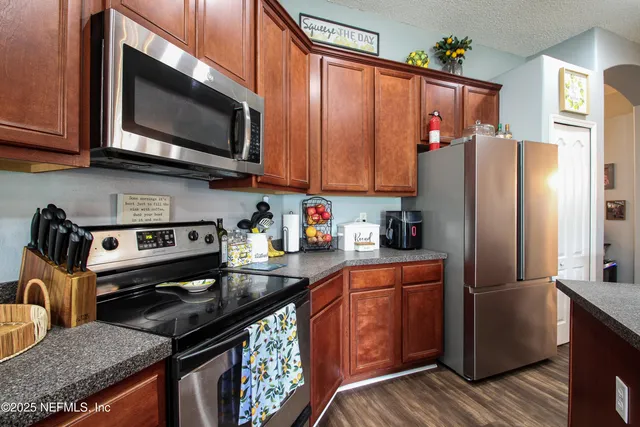 a kitchen with stainless steel appliances granite countertop a refrigerator stove top oven a sink and dishwasher