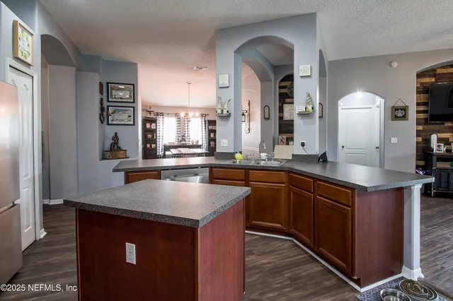 a kitchen with stainless steel appliances granite countertop a sink a stove and a refrigerator