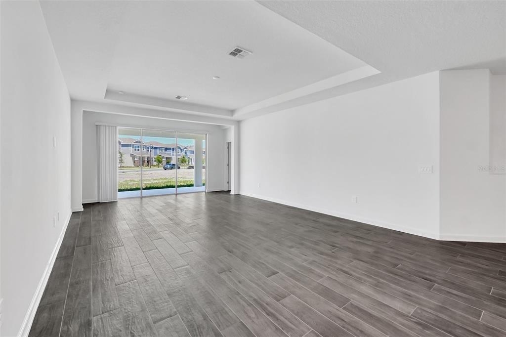 5768 Stephens Road St. Cloud, FL 34771 - Photo 13 of 50 a view of an empty room with wooden floor and a window