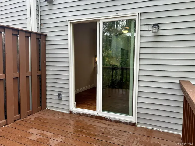 a view of an empty room with wooden floor and window
