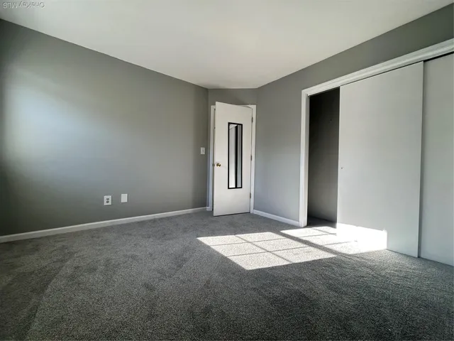 an empty room with windows and closet
