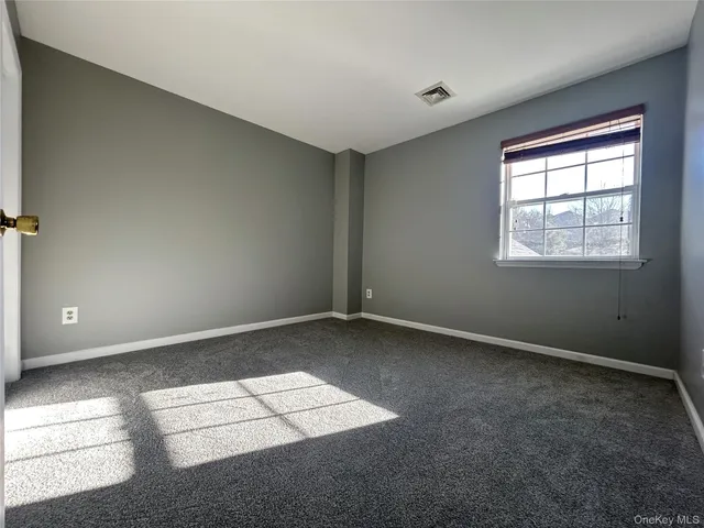 a bedroom with a large bed and windows
