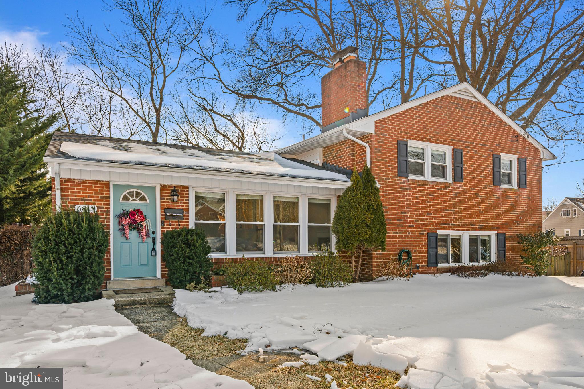 front view of a brick house with a yard