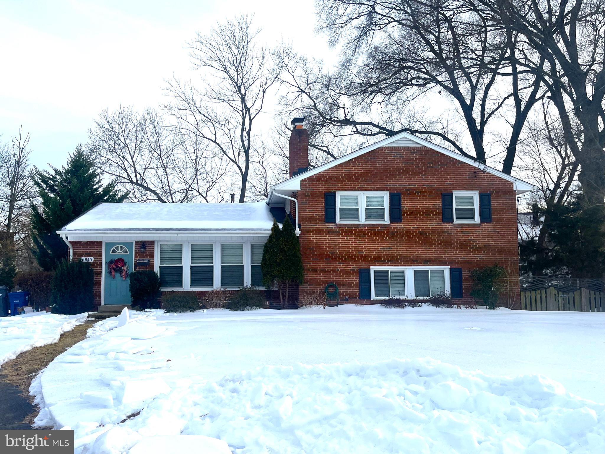 Charming brick home blanketed in snow.