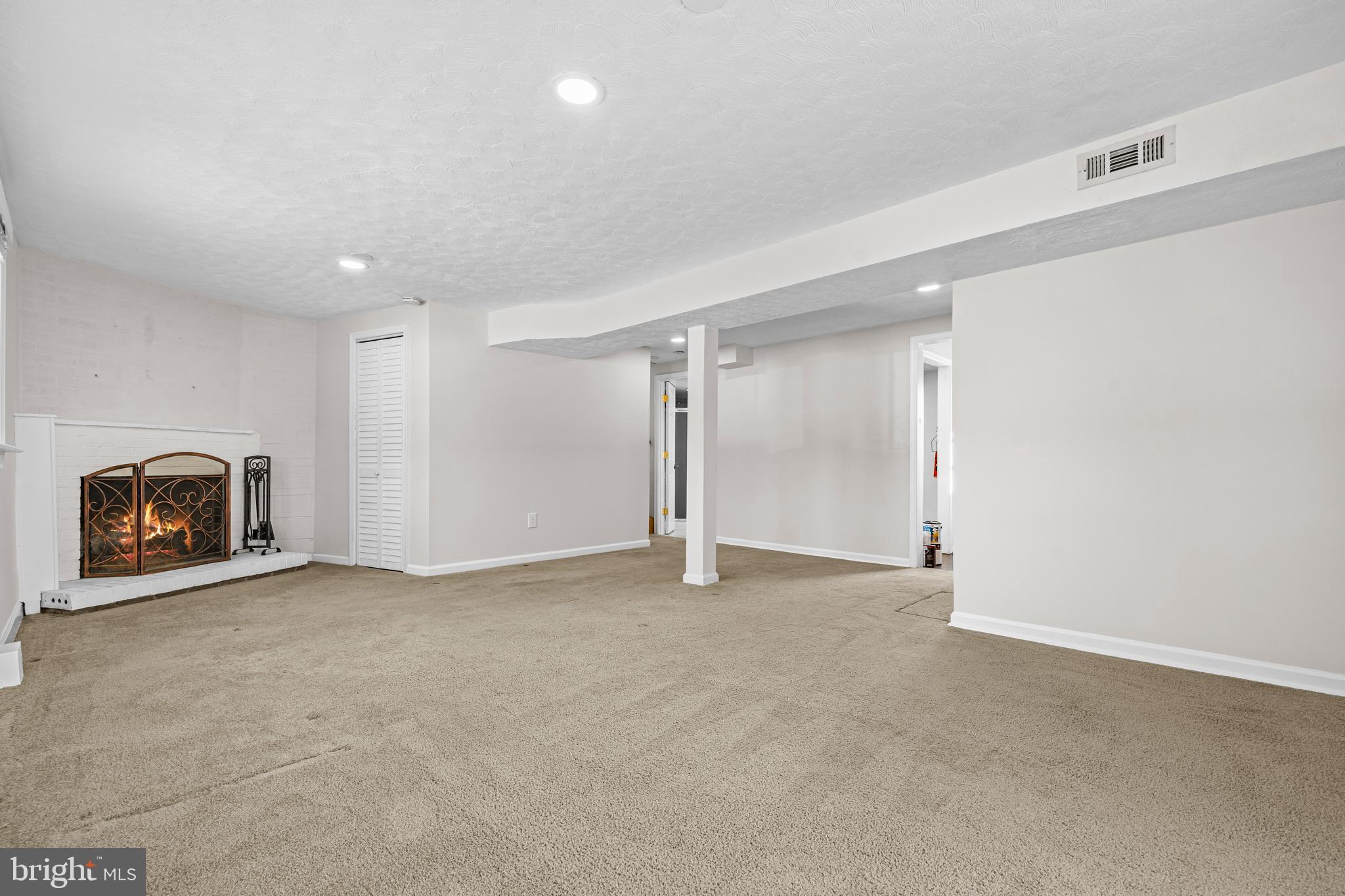 6813 Derrell Court Alexandria, VA 22307 - Photo 29 of 34 an empty room with a fireplace and a chandelier