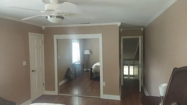 a view of a hallway with wooden floor and a chandelier