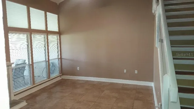 a view of an empty room with wooden floor and windows