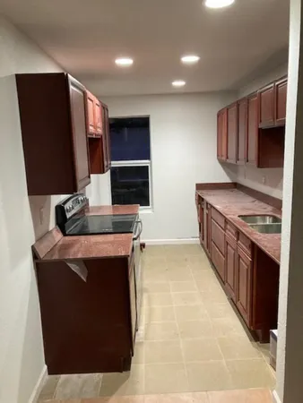 a kitchen with stainless steel appliances kitchen island granite countertop a stove a sink and a refrigerator