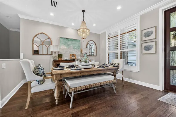 a view of a a dining room with furniture window and wooden floor
