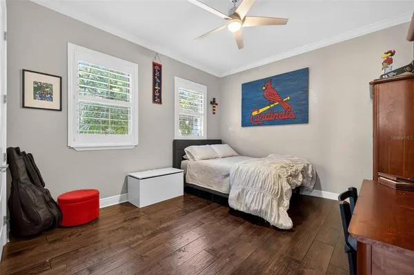 a bedroom with a bed and wooden floor