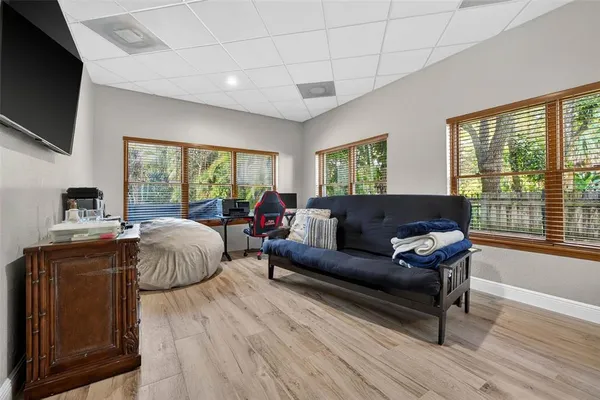 a living room with a bed furniture and a flat screen tv