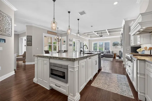 a open kitchen with sink and wooden floor