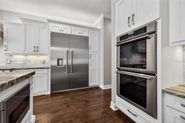 a kitchen with granite countertop a stove microwave and refrigerator