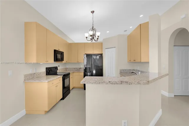 a kitchen that has a sink a microwave oven a stove and a refrigerator