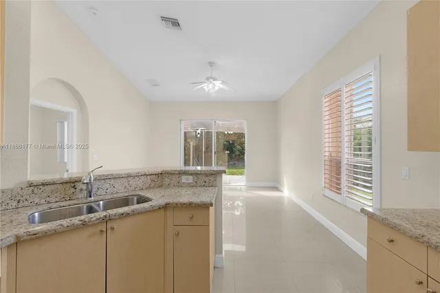 a bathroom with a granite countertop sink and a large mirror next to a window