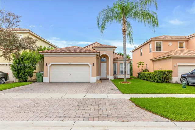 a front view of a house with a garden and yard