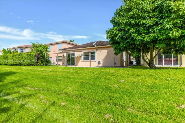a view of house that has a big yard