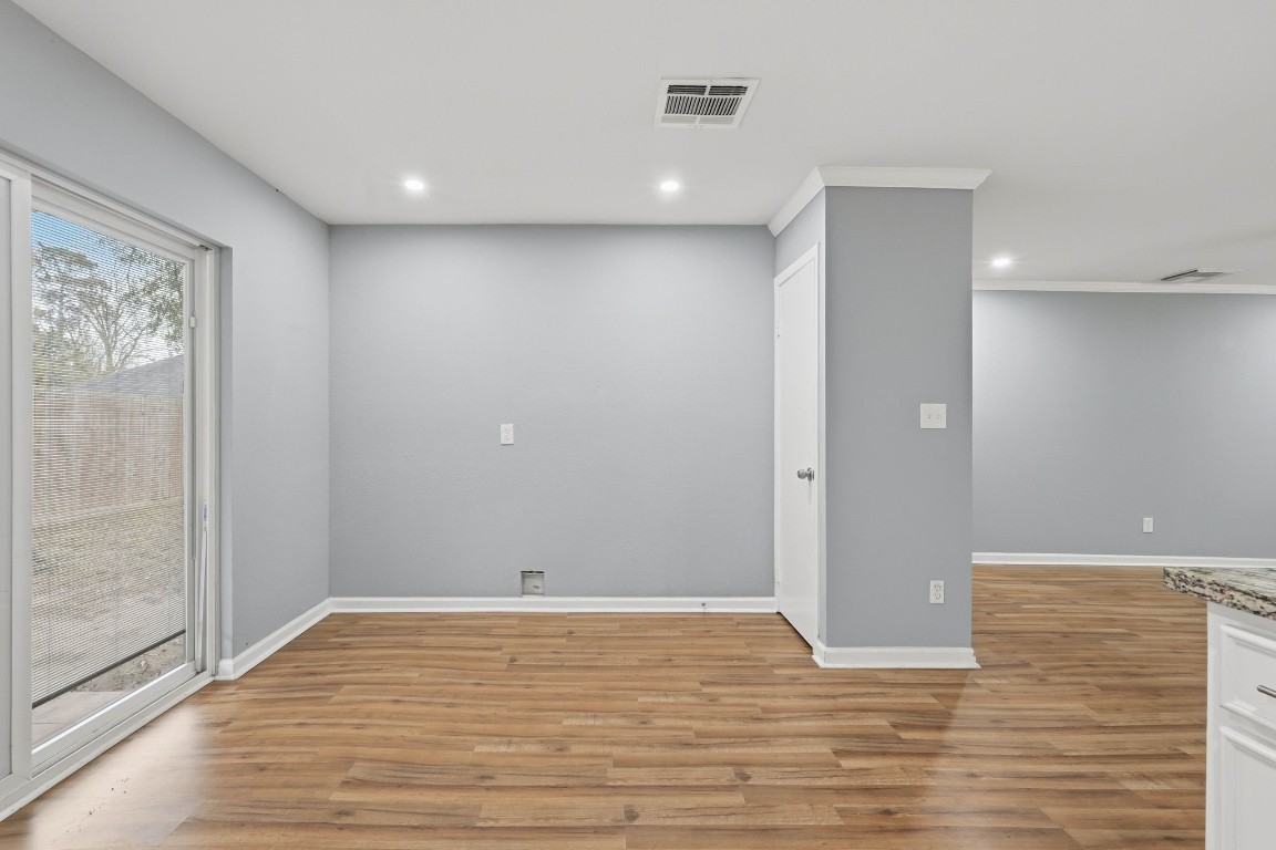 20 Moon Valley Court Conroe, TX 77304 - Photo 13 of 32 a view of an empty room with wooden floor and a window