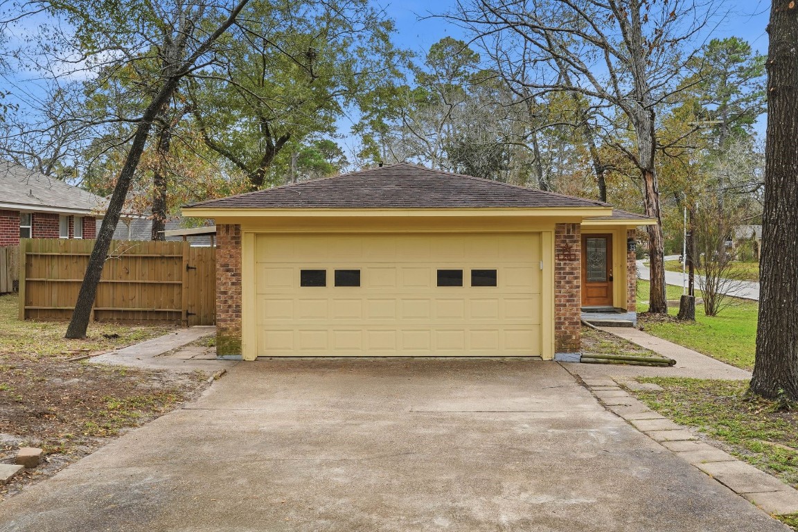 20 Moon Valley Court Conroe, TX 77304 - Photo 2 of 32 a view of a house with a large tree and a yard