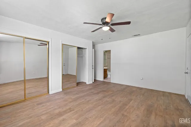 a view of a livingroom with a ceiling fan & entryway