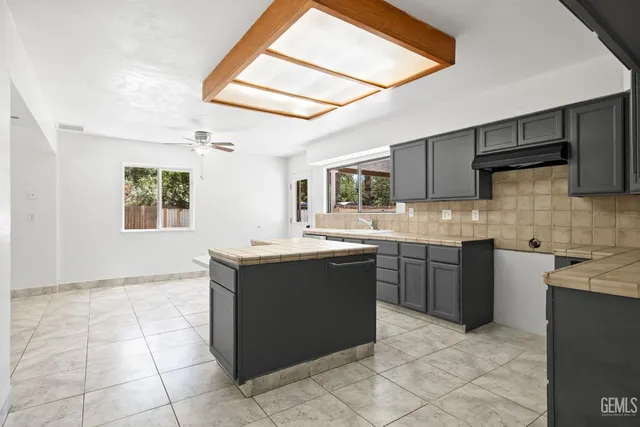 a kitchen with stainless steel appliances granite countertop a sink counter space cabinets and a window