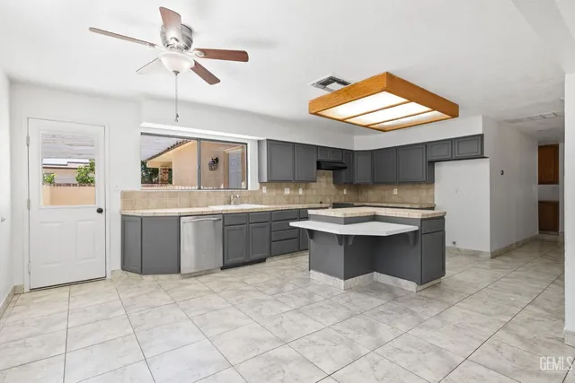 a kitchen with a sink counter top space cabinets and stainless steel appliances