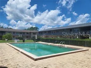 a view of house with swimming pool and yard in the background