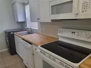 a kitchen with granite countertop a stove and a microwave