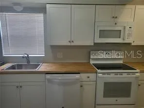 a kitchen with granite countertop white cabinets and a stove top oven
