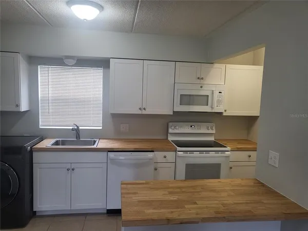 a kitchen with cabinets appliances a sink and a window
