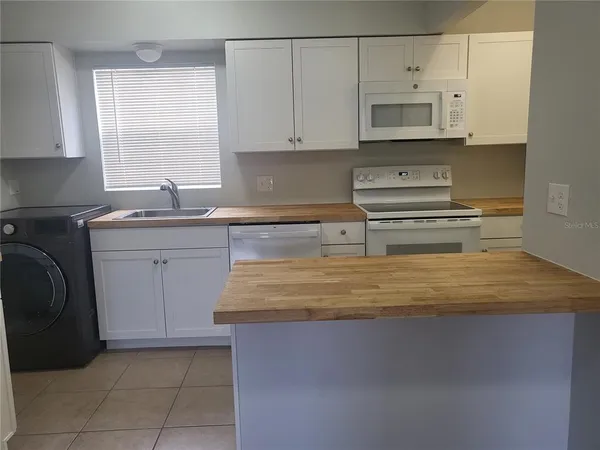 a kitchen with stainless steel appliances granite countertop a sink a stove and cabinets