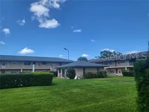 a view of a house with a big yard and a large tree