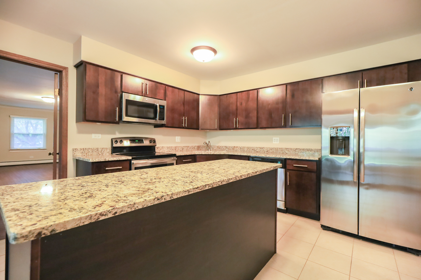 248 Florence Road Inverness, IL 60010 - Photo 6 of 25 a kitchen with kitchen island granite countertop a sink refrigerator and microwave