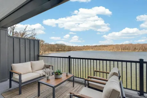 a roof deck with couches and sky view