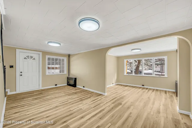 a view of a room with wooden floor and window