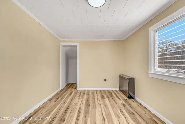 a view of a room with wooden floor and a window