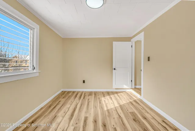 a view of a room with wooden floor and white walls