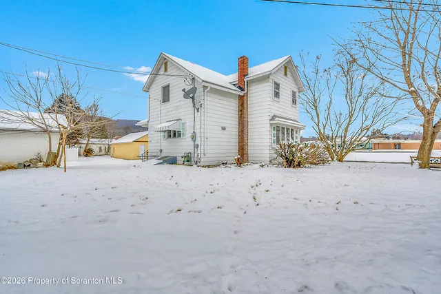 a view of a house with a snow in the background